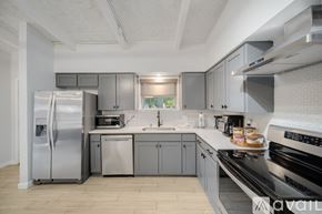 Irving house for rent - A kitchen with a stainless steel refrigerator and a stove top oven.