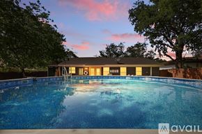 Dallas house for rent - A pool with a house in the background during sunset.