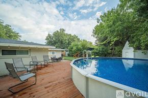 Irving house for rent - A pool with a deck and chairs in front of a house.