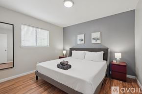 Carrollton house for rent - A bedroom with a large bed and a mirror on the wall.