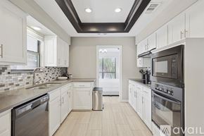 Allen house for rent - A modern kitchen with white cabinets and stainless steel appliances.