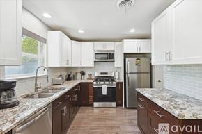 Richardson house for rent - A kitchen with white cabinets and a marble countertop.
