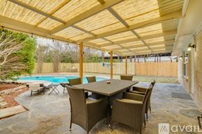 Dallas house for rent - A patio with a table and chairs and a pool.