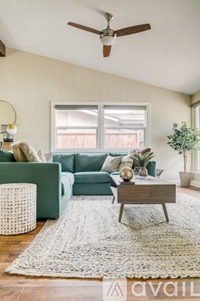 Dallas house for rent - A living room with a green couch, a wooden coffee table, and a white rug.