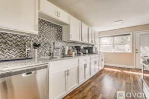 Dallas house for rent - A kitchen with white cabinets and a silver dishwasher.