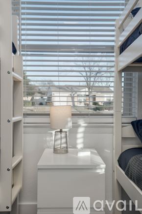 Dallas house for rent - A white bedroom with a bunk bed and a window with blinds.