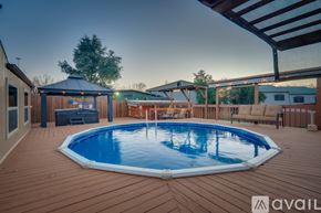 Dallas house for rent - A wooden deck with a round blue pool in the middle.