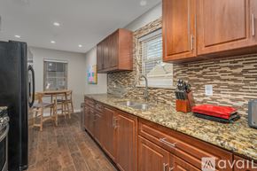 Dallas house for rent - A kitchen with wooden cabinets and a granite countertop.