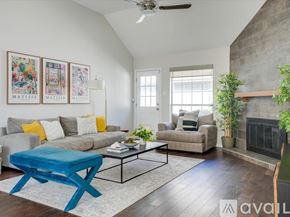 Dallas house for rent - A living room with a blue ottoman and a fireplace.
