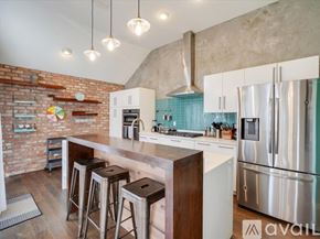 Dallas house for rent - A kitchen with a brick wall and stainless steel appliances.