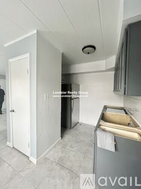 Schiller Park apartment for rent - A kitchen with a white door and a black fridge.