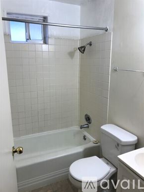 Seattle apartment for rent - A white toilet sits next to a bathtub in a bathroom.