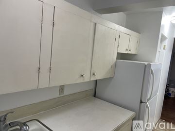 Seattle apartment for rent - A kitchen with white cabinets and a white fridge.