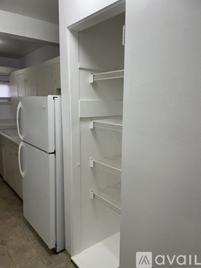 Seattle apartment for rent - A white refrigerator with empty shelves in a kitchen.