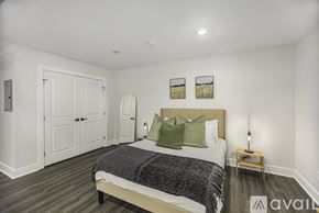 Grand Rapids apartment for rent - A bedroom with a bed, two pictures on the wall, and a wooden nightstand.