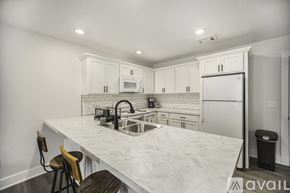 Grand Rapids apartment for rent - A kitchen with white cabinets and a marble countertop.