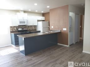 El Cajon apartment for rent - A kitchen with white appliances and wooden floors.