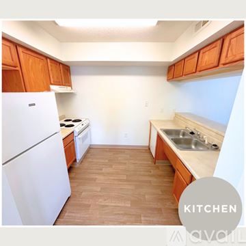 Des Moines apartment for rent - A kitchen with wooden cabinets and a white refrigerator.