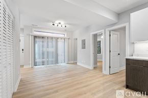 Chicago apartment for rent - A spacious room with wooden flooring and white walls.