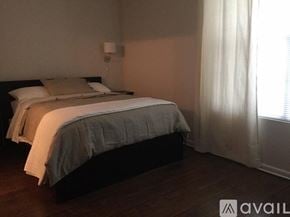 Ruston apartment for rent - A bedroom with a bed, pillows, and a lamp.