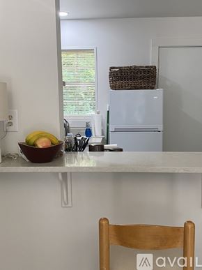 Ruston house for rent - A kitchen with a white fridge, a bowl of fruit, and a wooden chair.