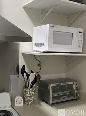 Ruston house for rent - A white microwave oven is mounted on a wall above a toaster oven.