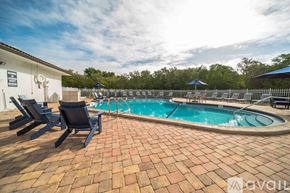 Clearwater apartment for rent - A pool surrounded by a brick patio and lounge chairs.