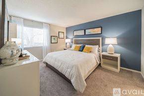 Clearwater apartment for rent - A bedroom with a white bed and a blue wall.
