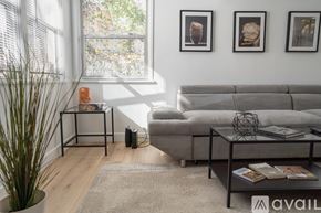 Los Angeles apartment for rent - A living room with a grey sofa, a coffee table, and three framed pictures on the wall.
