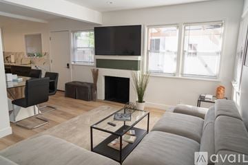 Los Angeles apartment for rent - A living room with a grey couch and a fireplace.