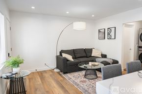 Los Angeles apartment for rent - A living room with a grey couch, a small table, and a rug.