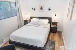 Los Angeles apartment for rent - A bedroom with a large bed and a window with white curtains.