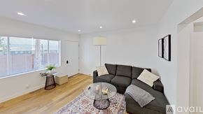Los Angeles apartment for rent - A living room with a grey couch, a glass table, and a rug.