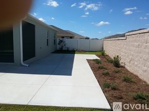 The Villages house for rent - A sunny day in a residential area with houses and a fence.