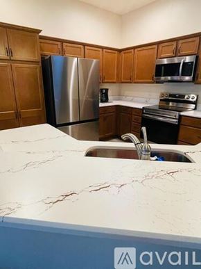 The Villages house for rent - A kitchen with a marble countertop and stainless steel appliances.