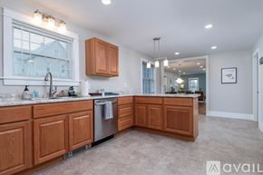 Rutland house for rent - A kitchen with wooden cabinets and a large window.