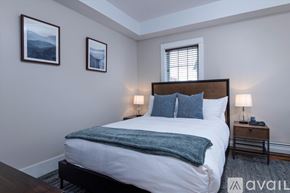 Rutland house for rent - A bedroom with a bed, two lamps, and two pictures on the wall.