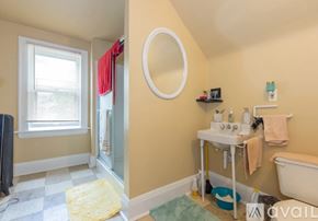 Cleveland Heights house for rent - A bathroom with a tub, sink, and window.