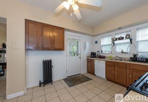Cleveland Heights house for rent - A kitchen with a white door and brown cabinets.