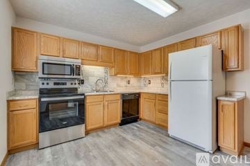Johnson City townhouse for rent - A kitchen with wooden cabinets and a white refrigerator.