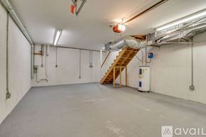 Johnson City townhouse for rent - A spacious room with a staircase, white walls, and a concrete floor.