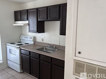 Kenner apartment for rent - A kitchen with black cabinets and a white stove.