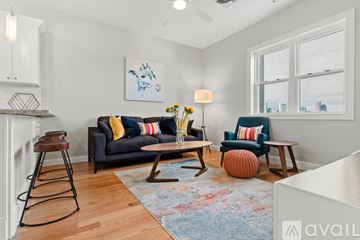 Boston apartment for rent - A living room with a grey couch and a wooden stool.