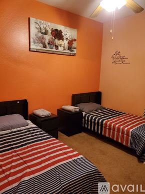 Phoenix apartment for rent - A bedroom with two beds and a painting on the wall.