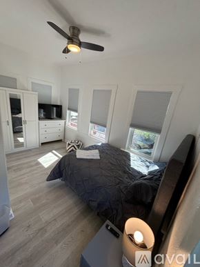 San Diego apartment for rent - A bedroom with a bed, a ceiling fan, and a television.