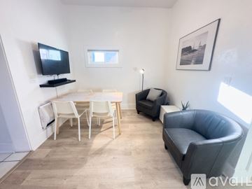 San Diego apartment for rent - A living room with a grey couch, a white table, and a television on a stand.