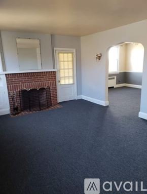 Baltimore apartment for rent - A room with a fireplace and a mirror on the wall.