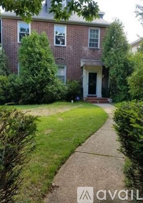 Baltimore apartment for rent - A brick house with a front yard and a sidewalk.