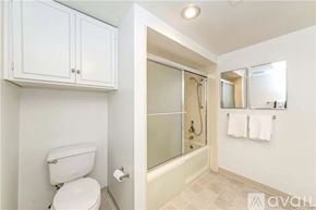Laguna Woods townhouse for rent - A white toilet sits next to a walk-in shower with a glass door.