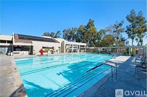 Laguna Woods townhouse for rent - A large outdoor swimming pool with a diving board and lane markers.